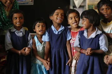 Happy children learning on laptops in a classroom