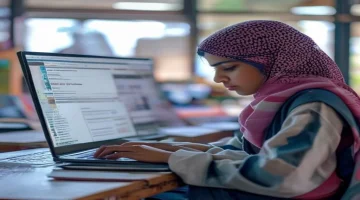 Student diligently working on a laptop with the Madrasati platform visible on screen showi